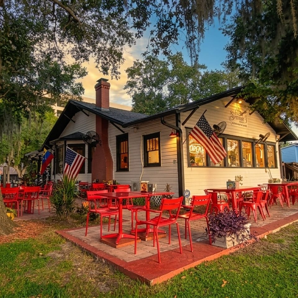 Cuban restaurant with red outdoor seating, American and Cuban flags, and oak trees draped in Spanish moss.